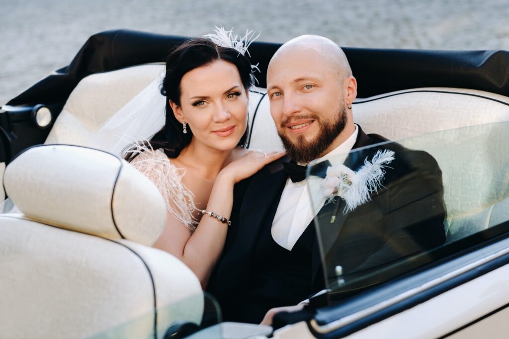 Elegant wedding couple In the courtyard of the castle in a retro car